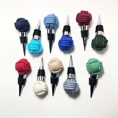 Set of colorful knot-shaped bottle stoppers on a white background